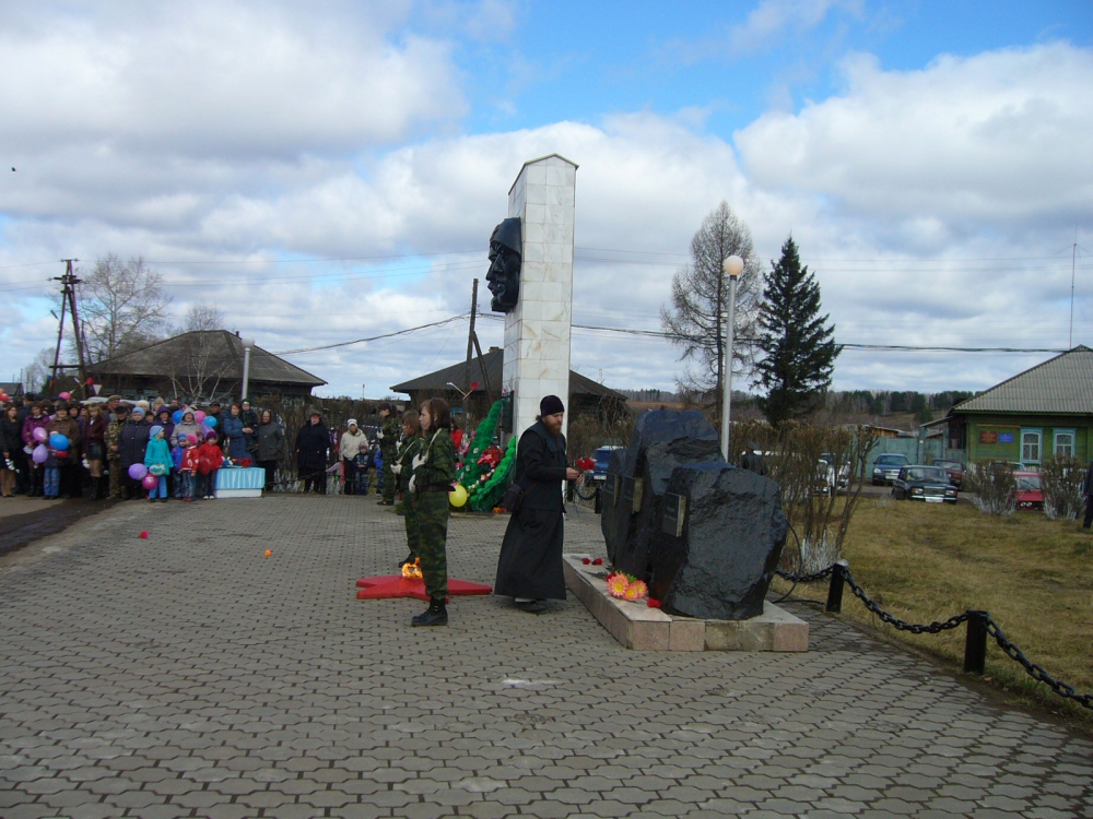 Настоятель храма иерей Владимир Фролов возлагает цветы к монументу Славы.